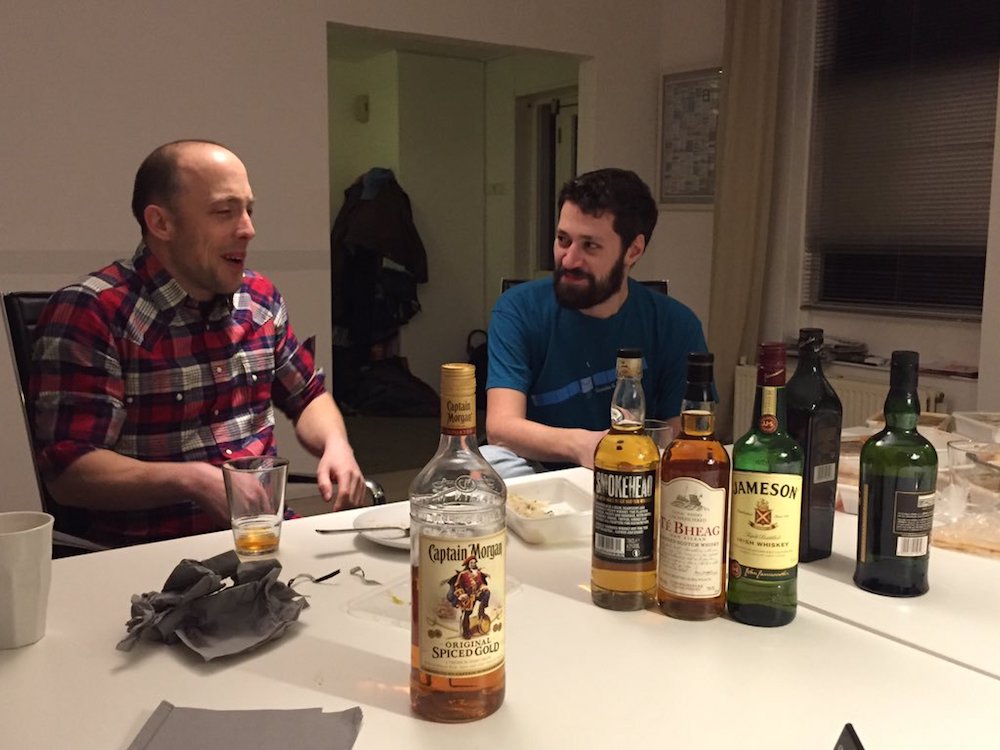 Job and Zoë having a conversation with bottles of whisky in the foreground.